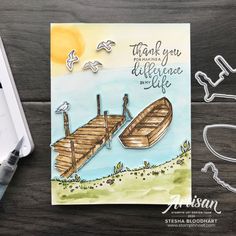 a handmade card featuring a boat and seagulls on the beach with watercolor paper