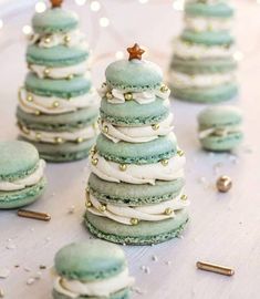 green macaroons with white frosting and gold sprinkles on a table