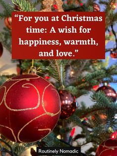 a red christmas ornament hanging from a tree with a quote on it that reads for you at christmas time a wish for happiness, warmth and love