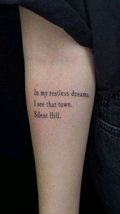 a person with a tattoo that reads in my restless dreams, i see that town silent hill