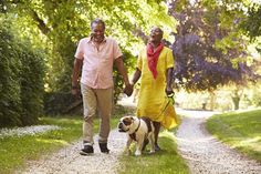 an older couple walking their dog on a path