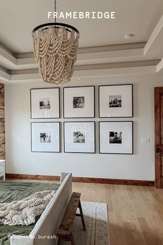 a chandelier hanging from the ceiling in a bedroom with pictures on the wall