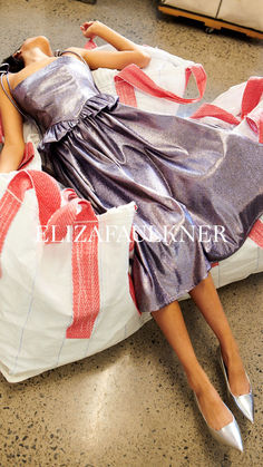 a woman laying on top of a white bag