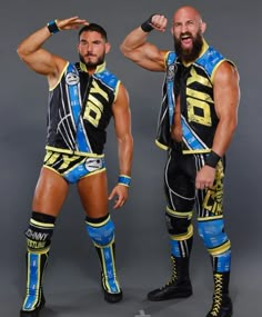 two men standing next to each other wearing wrestling gear