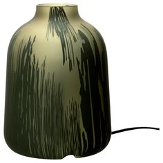 a green vase sitting on top of a white table next to a black corded light