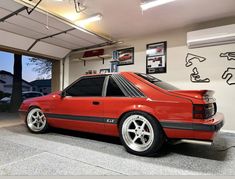 a red car is parked in a garage