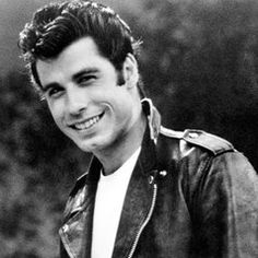 a black and white photo of a man in a leather jacket smiling at the camera