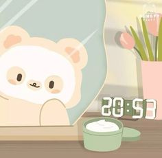 a white teddy bear sitting on top of a table next to a cup and clock