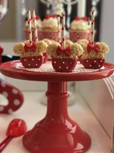 there are cupcakes with candles in the shape of hearts on a red plate