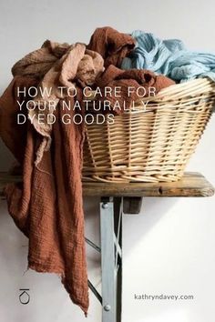 a wicker basket sitting on top of a wooden shelf next to a pile of clothes