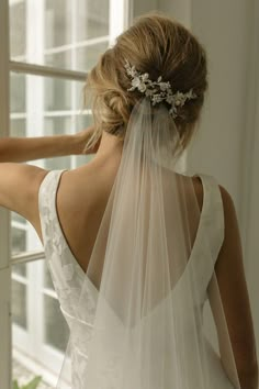 the back of a bride's dress with a veil on her head