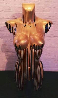 a ceramic sculpture of a woman's torso with black and white stripes on it