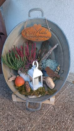 a metal tray with plants, rocks and a lantern on it that says welcome autumn