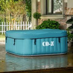 an inflatable pool sitting on top of a wooden deck next to a house