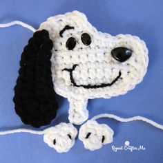 a crocheted dog is laying down on the blue surface with its eyes closed