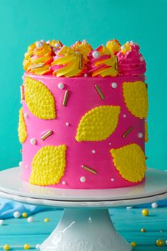 a pink cake with yellow frosting and sprinkles