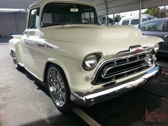 an old white truck parked in a parking lot