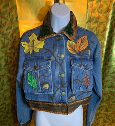 a blue jean jacket with leaves on it