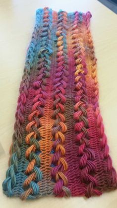 a multicolored knitted blanket sitting on top of a table