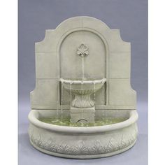 a white fountain with water flowing from it's sides