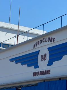 an aeroclube sign on the side of a building with blue shutters