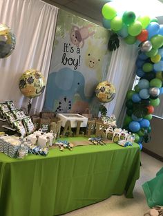 a green table topped with lots of balloons