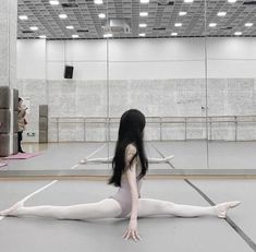 a woman is sitting on the floor with her legs spread out in front of her