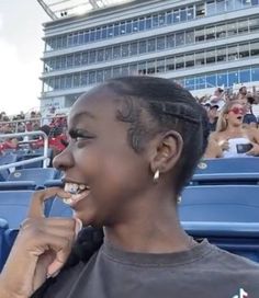 a woman brushing her teeth while sitting in the stands