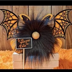 an orange and black bat decoration on top of a wooden block with a sign that says i love you more to blue