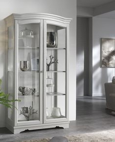 a white china cabinet with glass doors in a living room