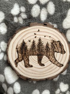 a bear and birds carved into a wood slice on a polka dot blanket with white dots