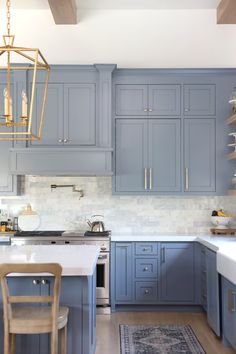 a kitchen with blue cabinets and white counter tops