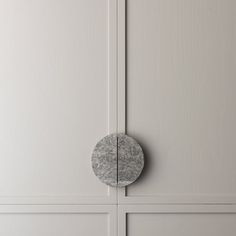 a white cabinet with a gray round knob on it's front door and the bottom panel is painted off