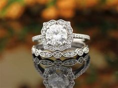 a close up of two rings on top of each other with a diamond in the middle