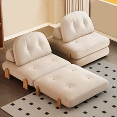 two white couches sitting next to each other on top of a rug