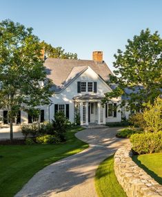 a white house surrounded by trees and grass