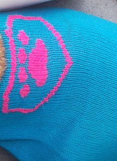 a teddy bear wearing a blue sweater with pink lipstick on it