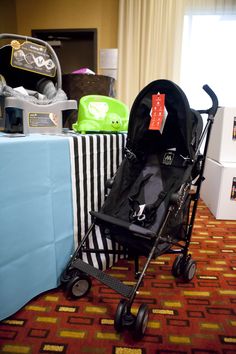 a baby stroller sitting on top of a carpeted floor next to a table