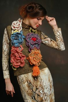 a woman in a dress with flowers on her neck and arms, posing for the camera