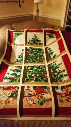 a christmas tree quilted on top of a couch in front of a wall lamp