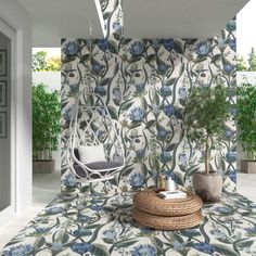 a room with blue and white flowers on the wall next to a wicker chair