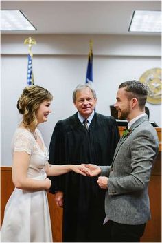 a man and woman standing next to each other in front of judge's robes