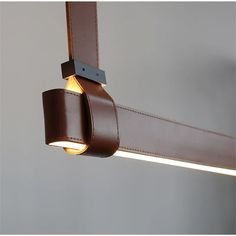 a close up of a light fixture on a ceiling with leather straps hanging from it