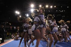 a group of cheerleaders are dancing on the floor in front of an audience