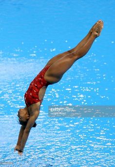 a woman diving into the water with her hands in the air