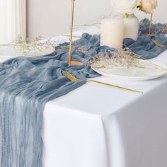 the table is set with white flowers and candles