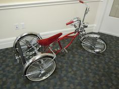 a red bicycle is parked in a room