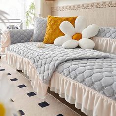 a bed with two pillows on top of it and an orange pillow in the middle