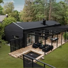 an aerial view of a black house in the woods