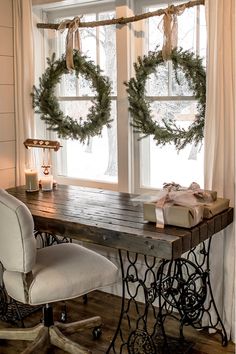 two wreaths are hanging on the window sill in front of a sewing machine